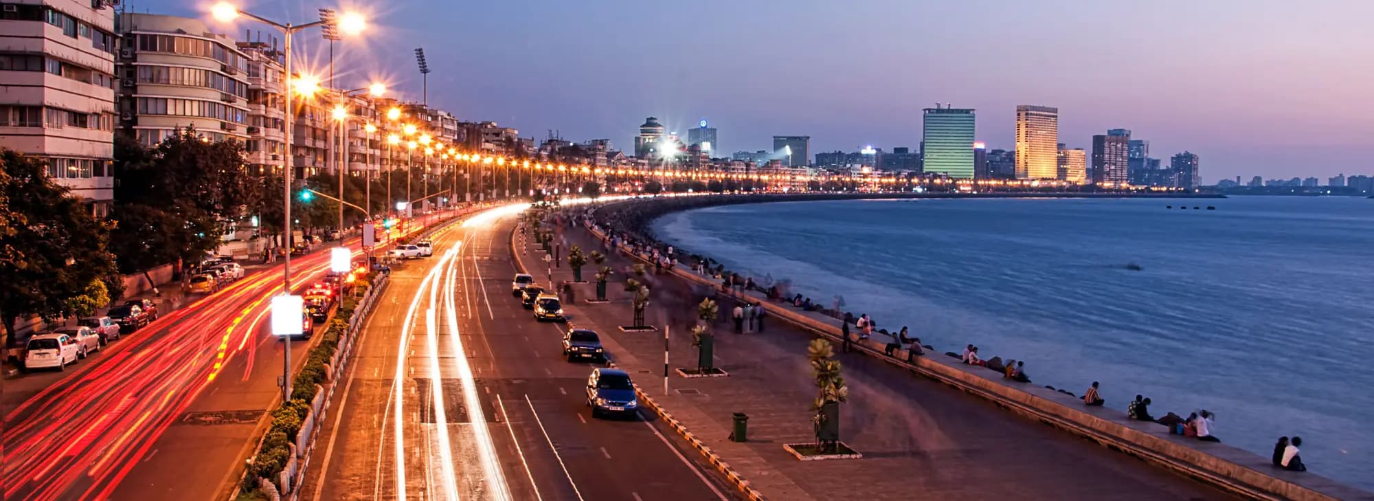 Mumbai city skyline at dusk, showcasing vibrant lights and iconic structures, perfect for a Mumbai tour experience.