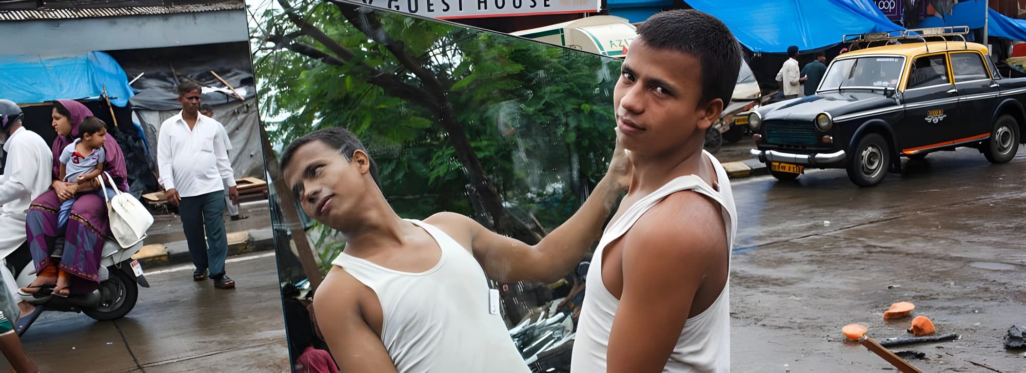 A man poses next to an oversized image of another man, highlighting a connection or tribute between them.
