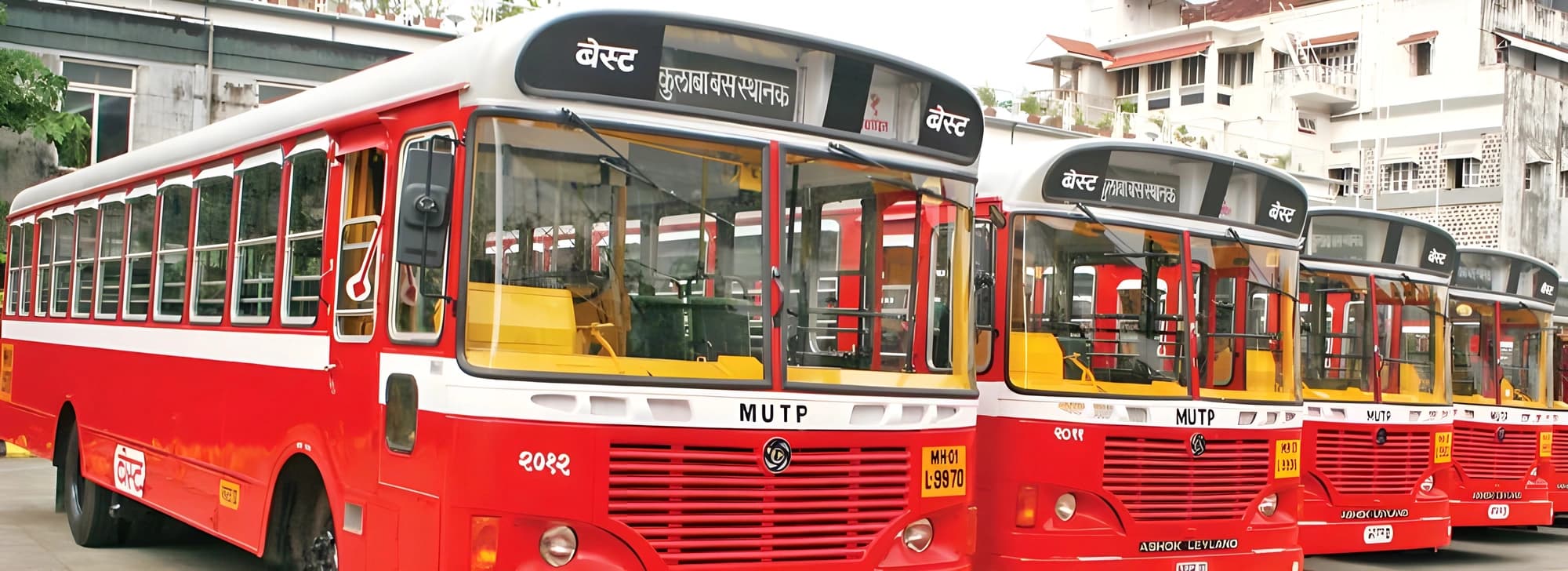 A row of red and white buses parked neatly in a line, showcasing their vibrant colors and organized arrangement.